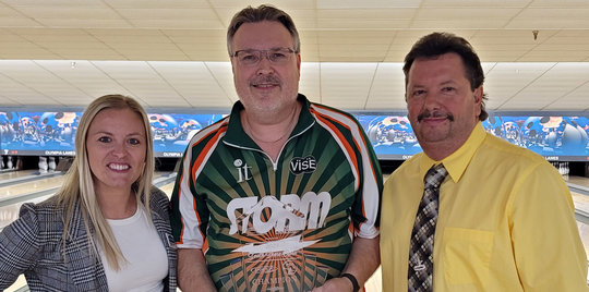 three bowlers standing side by side in front of a lane