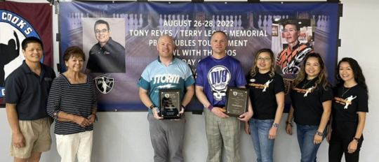 Champions PJ Haggerty and Rich Corwin pose with the families of Tony Reyes and Terry Leong